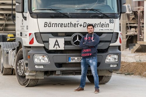 Berufskraftfahrer steht vor LKW