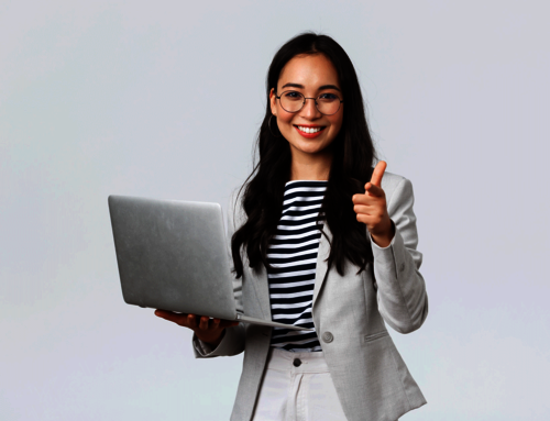 Frau im Hosenanzug hält einen Laptop in der Hand