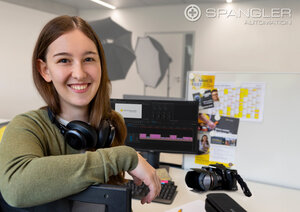 Junge Frau mit Kopfhörern um den Hals im Fotostudio