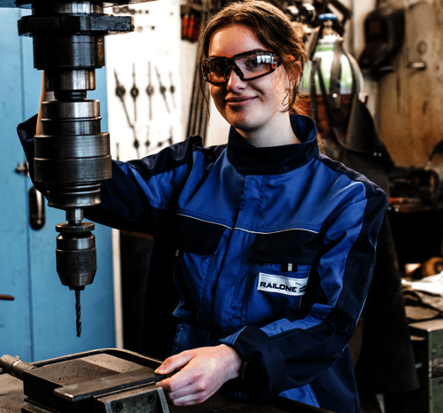 Junger Industriemechaniker steht an Bohrmaschine