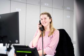 Industriekauffrau am Arbeitsplatz beim Telefonieren 